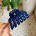 Detail of a large dark blue pumpkin-shaped hair claw clip with a glossy plastic finish - Sapphire Blue