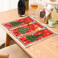 Close-up of a festive red Christmas placemat with green tree and snowflake patterns - Christmas Tree Style