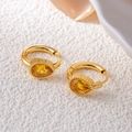 Close-up of gold drop earrings with yellow pear-cut crystal and textured metal hoop - Water Drop Zirconia / Yellow
