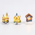Set of three illuminated resin Christmas village cottages with warm LED glow and snow detail - 3 Resin Glowing Miniature Houses