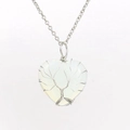 Macro shot of silver wire-wrapped tree of life on heart-shaped moonstone pendant - Silver + Opal