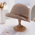 Detailed texture of breathable khaki woven sun hat with a brown bow on a wooden stand - Dark Brown