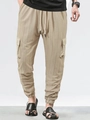 Detail of khaki cargo pants featuring vertical stripe texture and large side pockets - Khaki