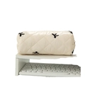 Cream quilted bow pencil case with black butterfly embroidery on a minimal desk - Beige