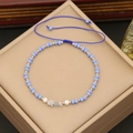 Macro detail of Bohemian beaded bracelet with blue stones, pearls and braided rope - Blue