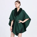 Elegant dark green knitted poncho with faux fur collar and decorative pom-poms on the hem - Dark Green