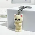 Vista dettagliata di un portachiavi a forma di gattino floccato bianco crema con anello - Beige