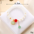 Détail d'un bracelet en perles avec breloque muguet et pendentif serrure ruyi verte - Style Nuage de Bon Augure Fu Blanc