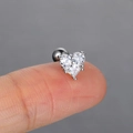 Close-up of a silver heart-shaped zircon ear stud with screw back on a fingertip - 7# Heart Shape / Platinum
