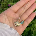 Dettaglio del ciondolo a conchiglia in oro 18K con perle e charm marino blu - Perla Conchiglia