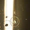 Golden suncatcher ornament with concentric metal circles and multi-faceted crystal prism - Design No.14