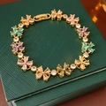 Nahaufnahme des goldenen Blumenarmband mit bunten Zirkonsteinen auf Lederbox - Mehrfarbiger Blumencluster-Stil (WB1531) / Bunt