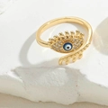 Macro shot of gold evil eye ring with blue enamel and sparkling pave stones on a stone base - Royal Blue Enamel (JZ0999-5)