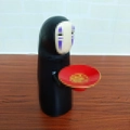 Kaonashi electronic piggy bank holding a red plate for automatic coin storage - Robe Character Battery Model