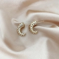 Vintage style twisted horn stud earrings in gold finish on champagne silk backdrop - Twisted Horn Minimalist