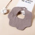 Detail view of flower-shaped baby bib made from soft brown crepe gauze fabric. - Light Purple