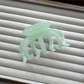 Detailed view of translucent mint green resin octopus hair claw on soft grey velvet tray - Green 3+4 Claw 10cm