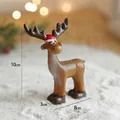 Miniature figurine de renne de Noël en résine avec bonnet rouge et fond bokeh doux - Ornement de renne