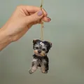 Yorkshire Terrier acrylic car charm with golden cord shown being held by hand - 1-Yorkie on Skateboard