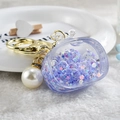 Detail of purple acrylic TV keychain with floating beads, gold ring, and large pearl charm - Noctilucent TV Style / Purple
