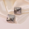 Boucles d'oreilles carrées argentées avec texture martelée sur fond en satin blanc - Style Argenté (HQ6023-1)