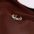 Close-up of vintage gold ring with blue enamel flowers and pink cat eye stones - Gold Blue Floral Cat's Eye Style