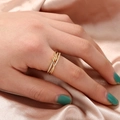 Detailed view of a gold knot ring with pave-set cubic zirconia on a silk background - Gold Crisscross Twist Style