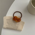 Detail of a brown acetate tortoise shell knot hair tie with a durable elastic band - Caramel color