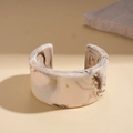 Close-up of retro marbled resin cuff bracelet with cream and brown textures - Beige (Marble Pattern)