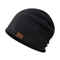 Close-up of black knitted beanie featuring a fine texture and brown leather F&S logo tag - Black