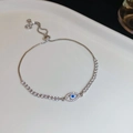 Detailansicht eines silbernen Evil-Eye-Armbands mit blauen Zirkonia und Zugverschluss - Silber