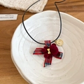 Dettaglio della collana con orsetto floccato, fiocco scozzese e cuore dorato - Rosso