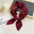 Elegant wine red pleated square scarf tied as a bow on a luxury textured background - Burgundy