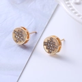 Macro detail of gold-plated round stud earrings with cross star pattern zircons - D15 Gold Round Star