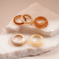 Detailed close-up of colorful resin acrylic rings on natural white stone slices - Coffee Set