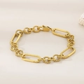 Close-up of golden mixed link chain bracelet with lobster clasp on beige surface - Gold