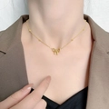 Elegant gold titanium steel bow necklace with delicate beads on a model wearing a blazer - Bead Bowknot Necklace - Gold