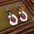 Nahaufnahme von Vintage Blumenohrringen mit buntem Emaille und glänzenden Strasssteinen - Silberne Nadel-Gold/Kaffee/Lila