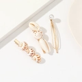 Macro detail of hair clips set featuring natural seashells, white pearl and golden metal frame - Spotted Conch Shell Pearl 3-Piece Headpiece Set