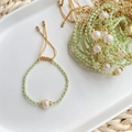 Detail of freshwater pearl and green crystal beaded bracelet on white ceramic tray - Dark Green