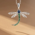 Exquisite silver dragonfly pendant necklace with blue and green gemstones on warm background - White Gold