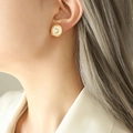 Orecchini tondi dorati con inserto in madreperla bianca e motivo lunare indossati dal modello - Orecchini / Oro
