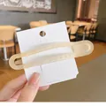 Elegant cream beige seamless hair clip in matte finish shown on a display card - Light Khaki