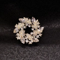 Macro shot of luxury wreath brooch with gold base and clear crystals on black background - Double Layer Wreath Style (X0366)