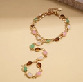 Dettaglio catena regolabile dorata con pietre ovali in resina colorata su sfondo beige - Bracciale Slave-Colorato