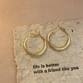 Close-up of golden twisted geometric hoop earrings on a textured paper background - Gold Small Round Hoop Style (52#)