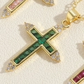 Macro di un ciondolo a croce placcato oro 14K con zirconi verde smeraldo e piccoli diamanti - Verde