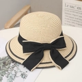Detailed weave of beige straw sun hat featuring an elegant oversized black ribbon bow - One Size / Beige