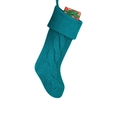 Close-up of teal cable-knit Christmas stocking with small gift boxes on white background - Teal