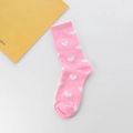 Detailopname van felroze sokken met witte hartpatronen en geribbelde manchetten - Eén maat / Roze